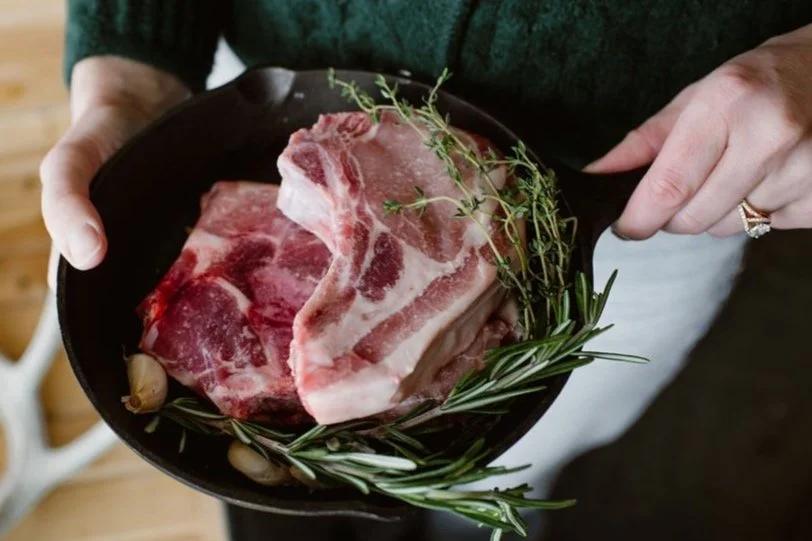 Raw pork ribs garnished with fresh herbs